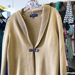 Tan sweater with snap buckle closure in front.